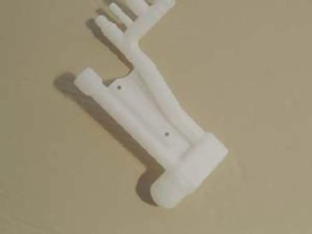 Weißer Siphon ohne Entlerung, mit mehreren Auslassrohren, auf einer neutralen Oberfläche. Produkt von Remeha, einfaches Design für Sanitärinstallationen.